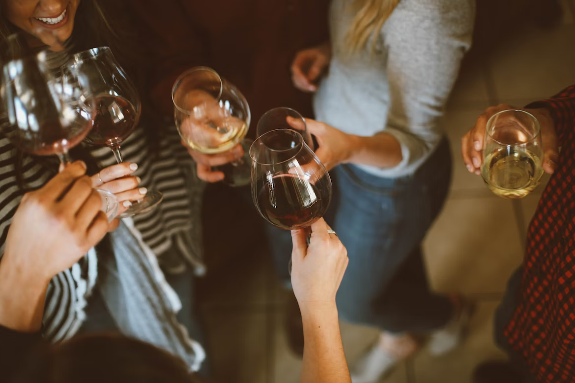 Groupe de personnes tenant des verres de vin rouge et de vin blanc