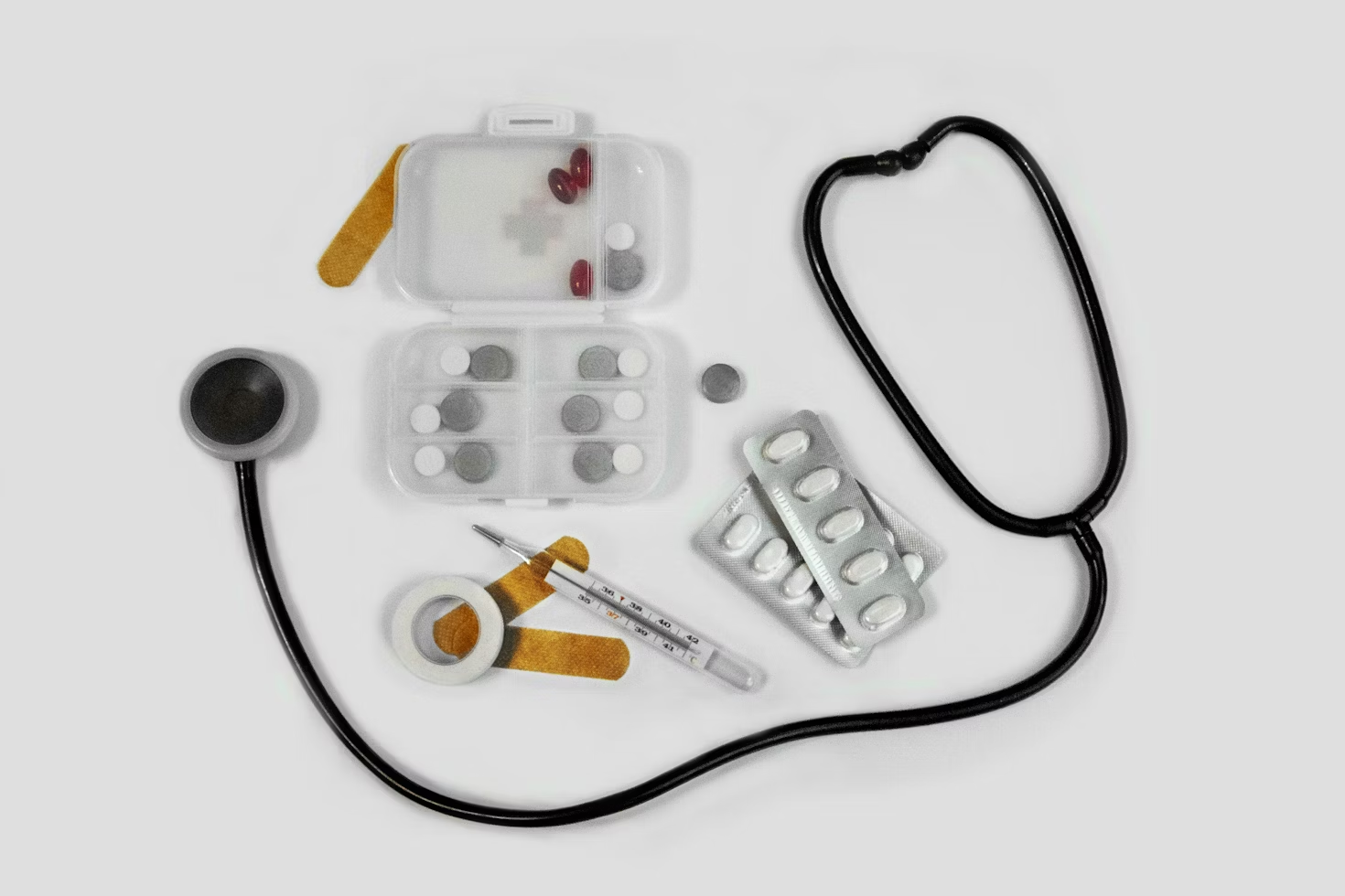 Stéthoscope posé à côté de médicaments d'un thermomètre de pansements et d'une boîte à médicaments