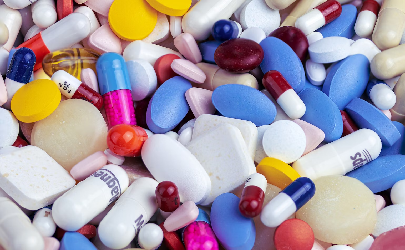 Ensemble de pilules de toutes les couleurs avec des médicaments bleus roses blancs jaunes et beige