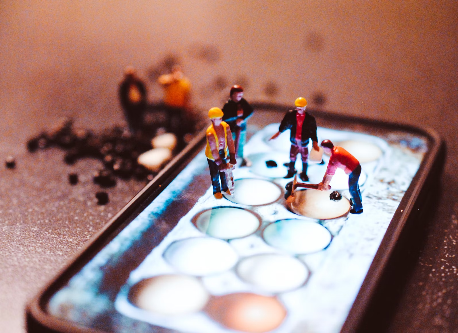 Minuscules figurines d'ouvriers travaillant sur un écran d'IPhone avec une image d'oeufs