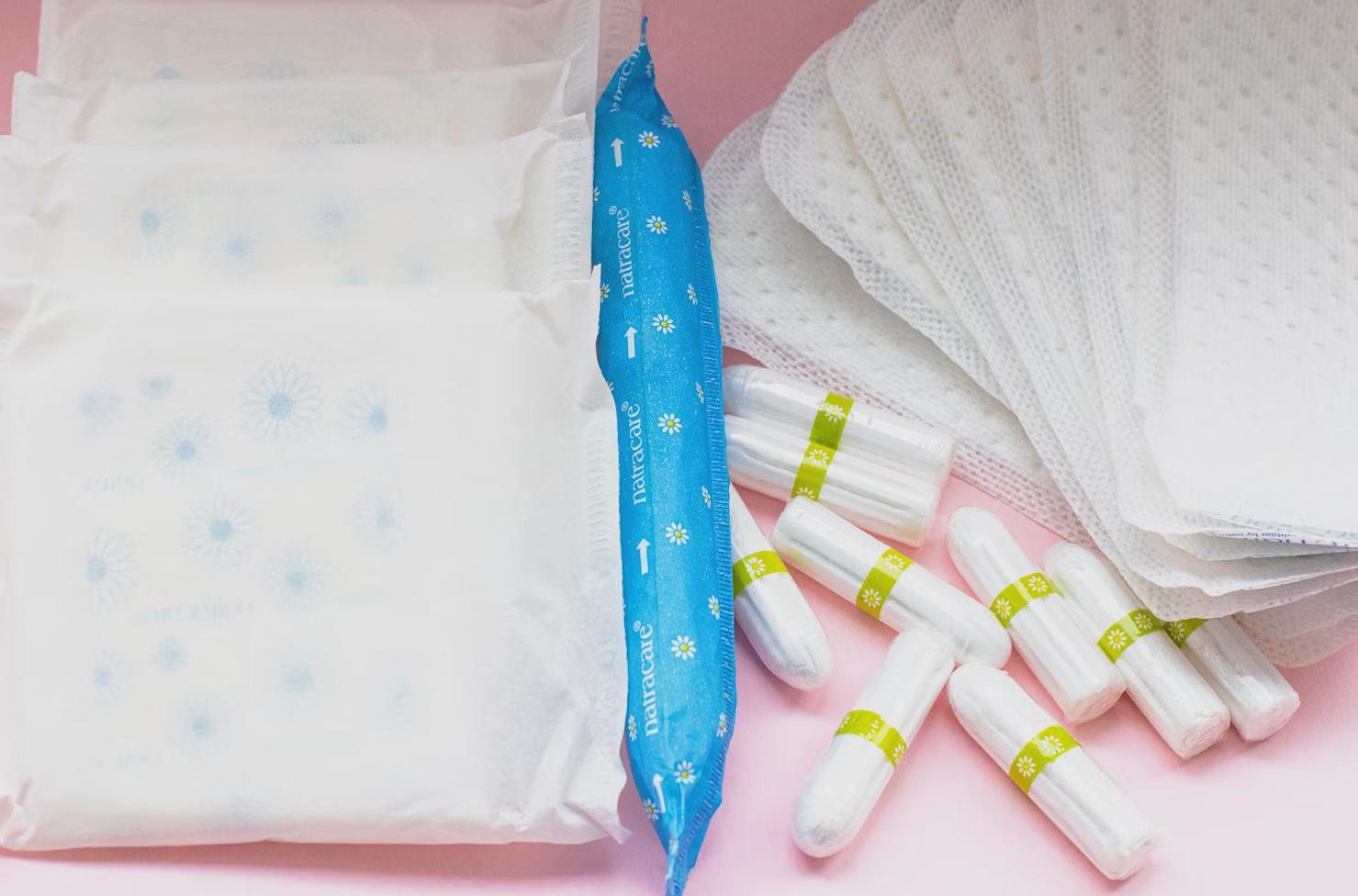 tampon menstruel bleu entouré de petits tampons et de serviettes hygiéniques
